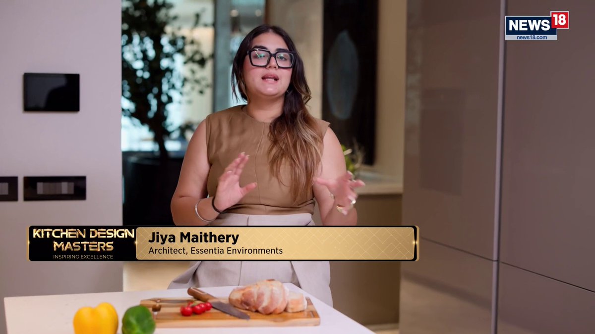 The image shows Jiya Maithery, an Architect at Essentia Environments, speaking on News18's "Kitchen Design Masters - Inspiring Excellence" segment, with a loaf of bread and vegetables on a cutting board in front of her.

This appears to be a mismatched clip, as the image content (a cooking/kitchen design show) does not relate to the accompanying post about Vivek Wadhwa discussing Trump's H-1B immigration policies and their potential impact on India.