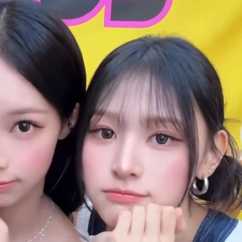 Two young women, one with dark hair and the other with lighter hair, posing closely together for a close-up shot.