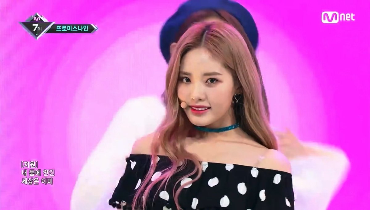 A screenshot from an Mnet broadcast showing K-pop idol (ji-won) during a performance, with Korean subtitles and Mnet and stage ranking graphics visible.