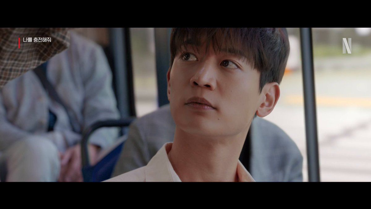 A handsome young man sits on a bus, gazing off to the side with a contemplative expression, while the Netflix "N" logo and Korean text "나를 충전해줘" (Charge Me Up) appear in the top corners, promoting the romantic comedy streaming on Netflix.