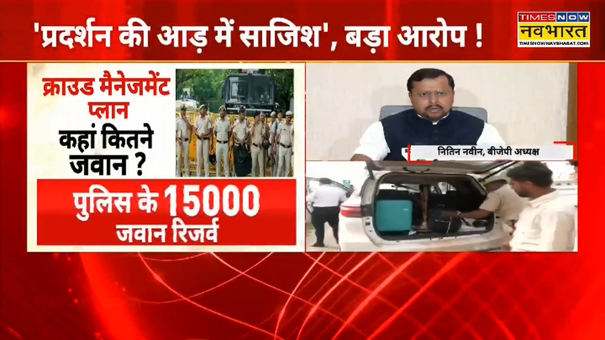 A Times Now Navbharat news broadcast screenshot with Hindi text reading 'प्रदर्शन की आड़ू में साजिश', बड़ा आरोप!' and 'पुलिस के 15000 जवान रिज़र्व', showing BJP spokesperson Nitin Navin and police imagery.