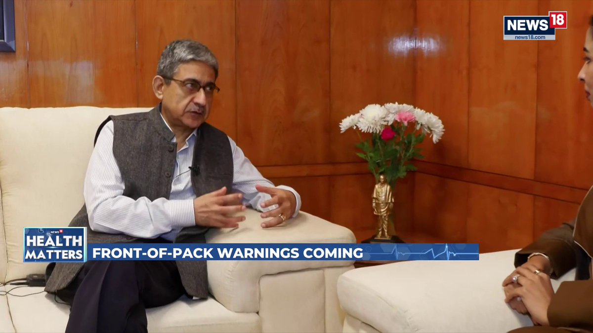 The image shows a man being interviewed on News18's Health Matters segment, with the headline "FRONT-OF-PACK WARNINGS COMING" displayed, relating to FSSAI's efforts to improve food product transparency and regulate canteens and e-commerce food platforms.