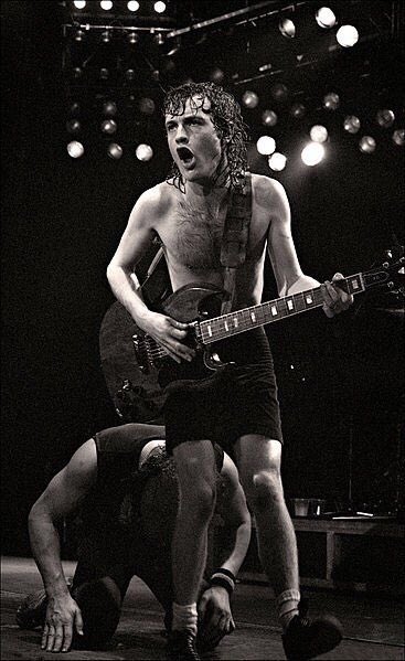 acdcbka's tweet photo. Angus Young in the Bon Scott years, when AC/DC was still fighting its way to the top. The schoolboy uniform dated back to 1974 in Sydney. It was his sister Margaret's idea, since Angus used to come home from school and grab his guitar without bothering to change. https://t.co/FJ3jvzkIGm