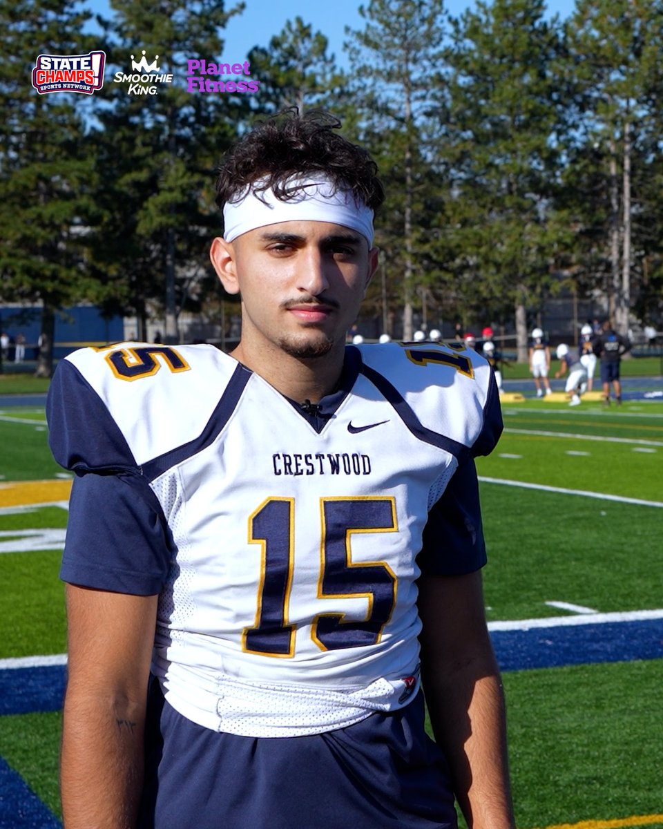 A young football player wearing a white and navy Crestwood #15 jersey and a white headband stands on a football field, with State Champs, Smoothie King, and Planet Fitness logos in the top left corner.