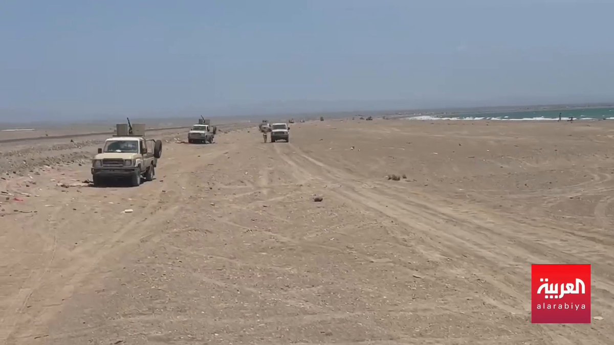 Vehicles driving along a sandy beach road with the ocean visible on the right, featuring the Al Arabiya (العربية) news logo in the bottom right corner.