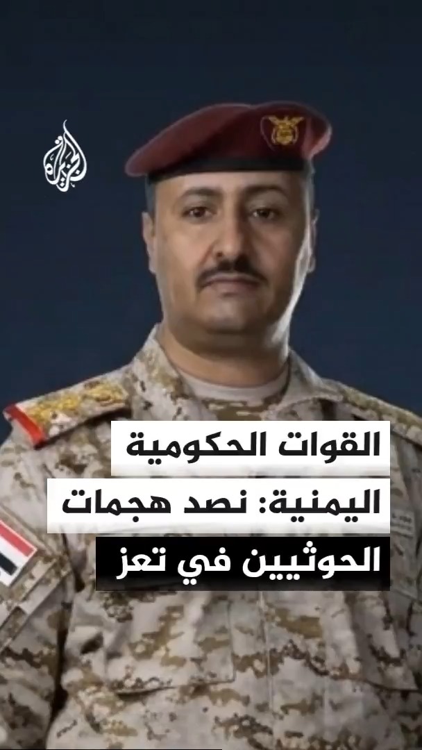A Yemeni government military spokesperson, wearing a maroon beret and desert camouflage uniform, is featured in what appears to be an Al Jazeera news broadcast. The Arabic text overlay reads "القوات الحكومية اليمنية: نصد هجمات الحوثيين في تعز" (Yemeni government forces: We are repelling Houthi attacks in Taiz), which aligns with the post about Yemeni forces announcing the repulsion of Houthi attacks on their positions in Taiz.
