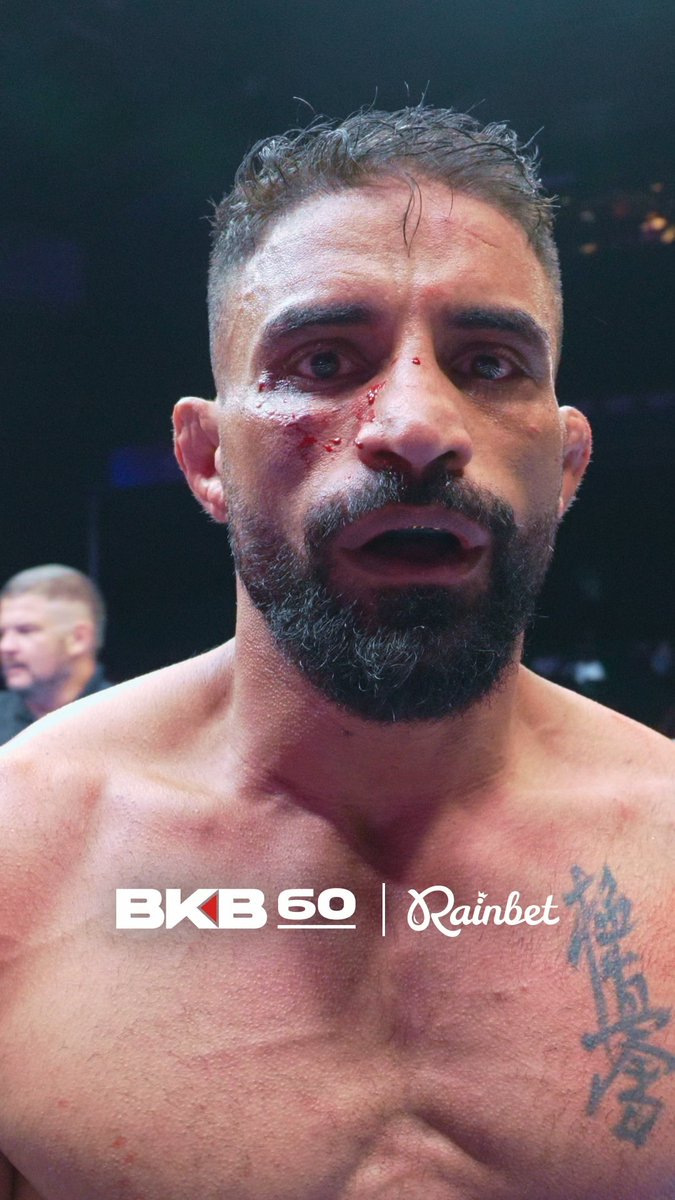 A close-up of a bearded fighter with blood on his face, with "BKB 60" and "Rainbet" branding visible at the bottom.