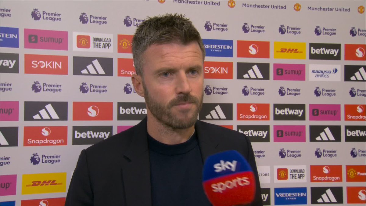 Michael Carrick speaks into a Sky Sports microphone during a Premier League post-match interview, with sponsor logos including Adidas, Betway, DHL, Snapdragon, and Vredestein, plus Manchester United branding visible on the backdrop. The image aligns with the caption, showing the Manchester United manager discussing his team selection and Amad Diallo's return following a match against Tottenham.