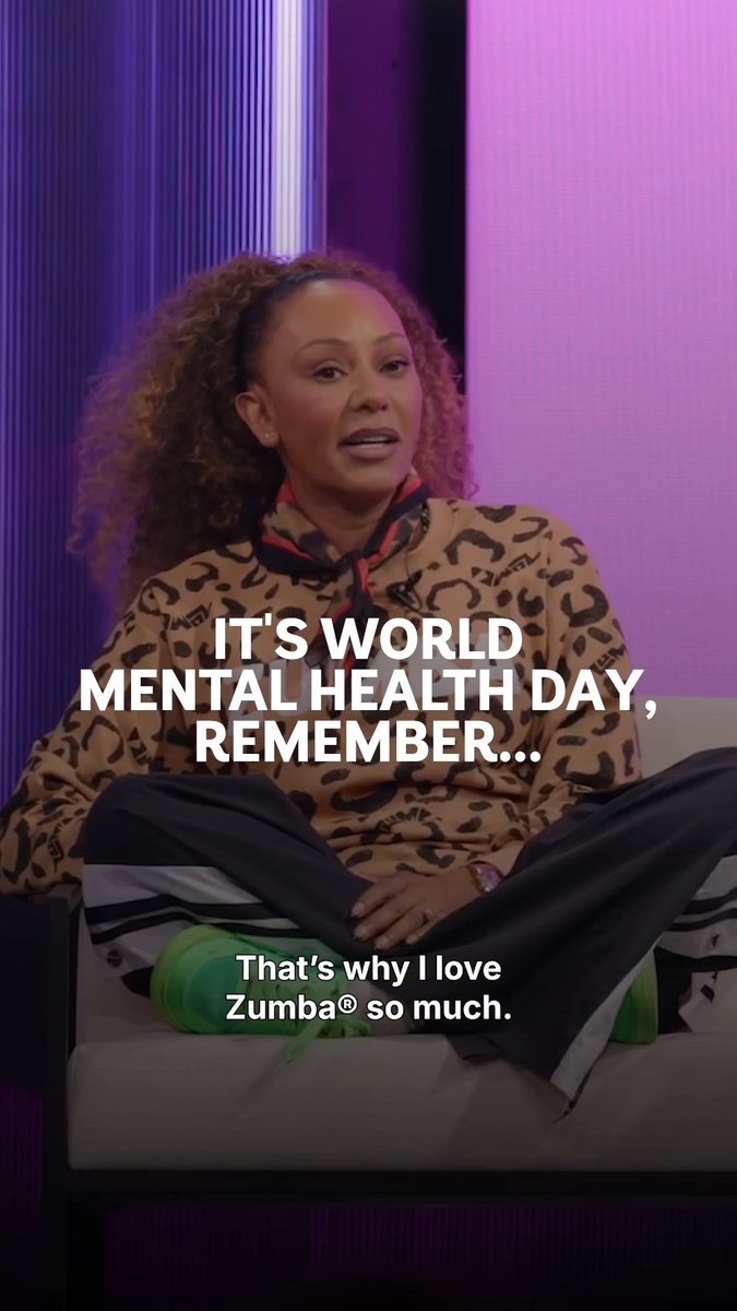 An interview still of singer Mel B wearing a leopard-print top with overlaid text reading 'IT'S WORLD MENTAL HEALTH DAY, REMEMBER...' and 'That's why I love Zumba® so much.'