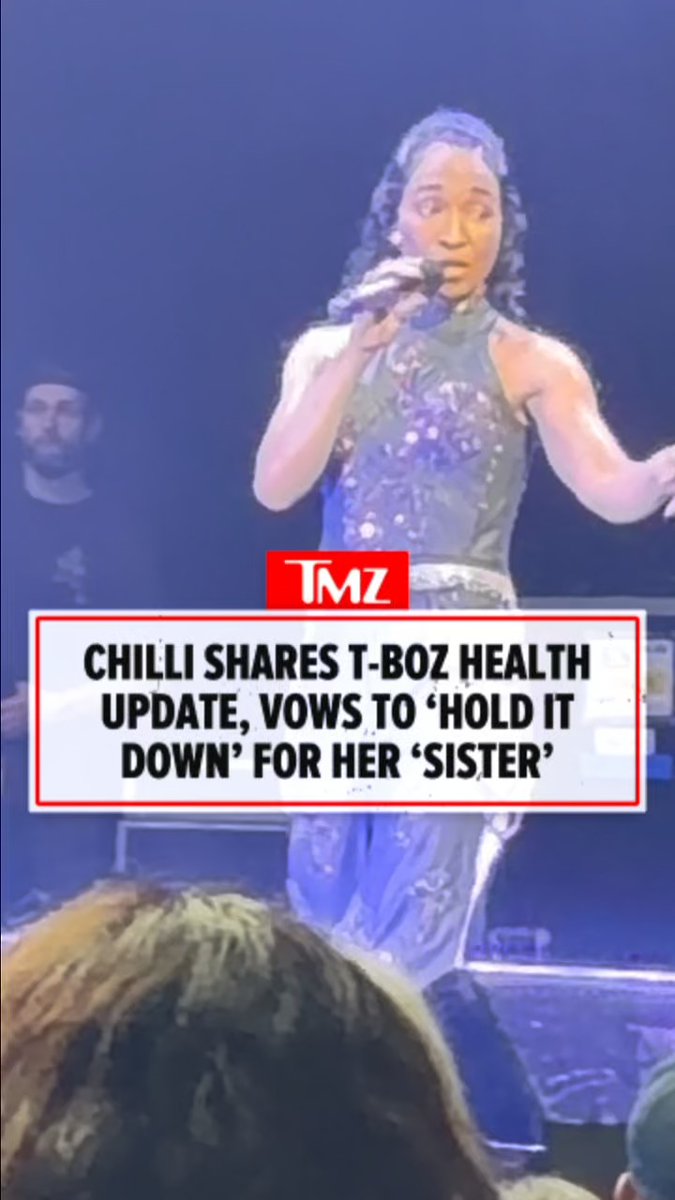 A performer (Chilli of TLC) sings into a microphone on stage at the Fontainebleau in Las Vegas, overlaid with TMZ text reading: "CHILLI SHARES T-BOZ HEALTH UPDATE, VOWS TO 'HOLD IT DOWN' FOR HER 'SISTER'." The image corresponds to the moment she addressed the crowd about T-Boz's recovery from a sickle cell crisis.