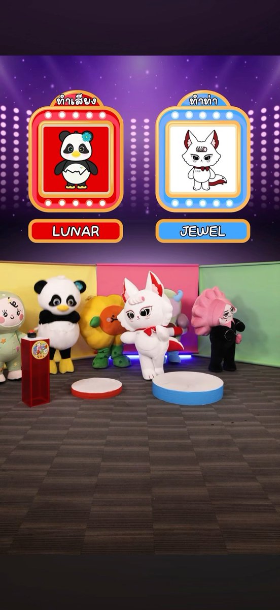 A colorful game show-style scene featuring costumed mascot characters including a panda, a yellow creature, a white fox, and a pink-haired figure, with on-screen labels 'LUNAR' and 'JEWEL' alongside Thai text.