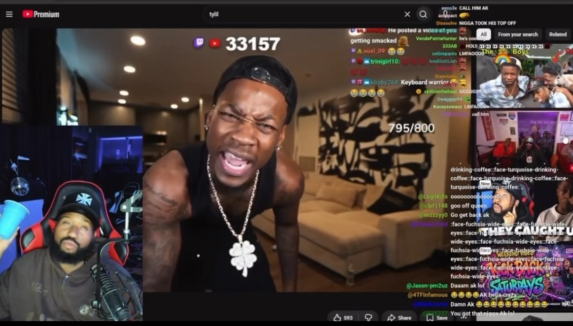A YouTube live stream hosted by streamer Tylil James shows a man in a black durag leaning toward the camera with an angry expression, while DJ Akademiks appears in a reaction feed on the right, and the live chat reacts with messages like "DAMN" and emojis to the confrontation over the Reggie situation.
