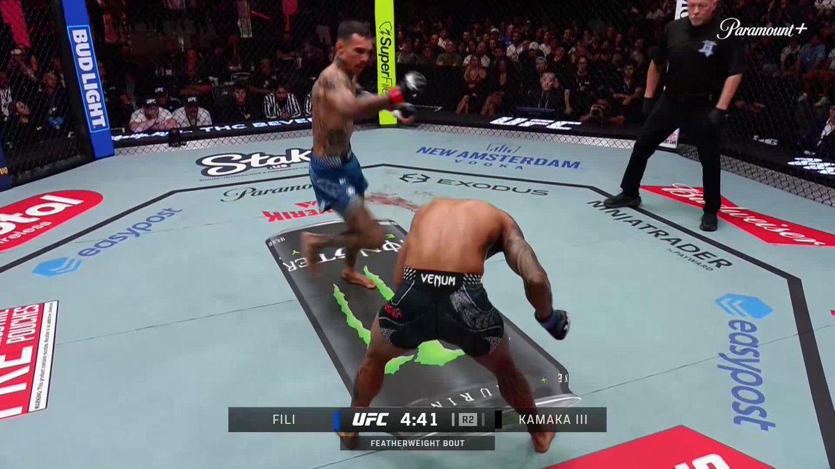 UFC fight scene between Fili and Kamaka III at 4:41 in Round 2 of a featherweight bout, with one fighter in blue shorts throwing a punch at his opponent in black Venum shorts, while a referee watches in the octagon.