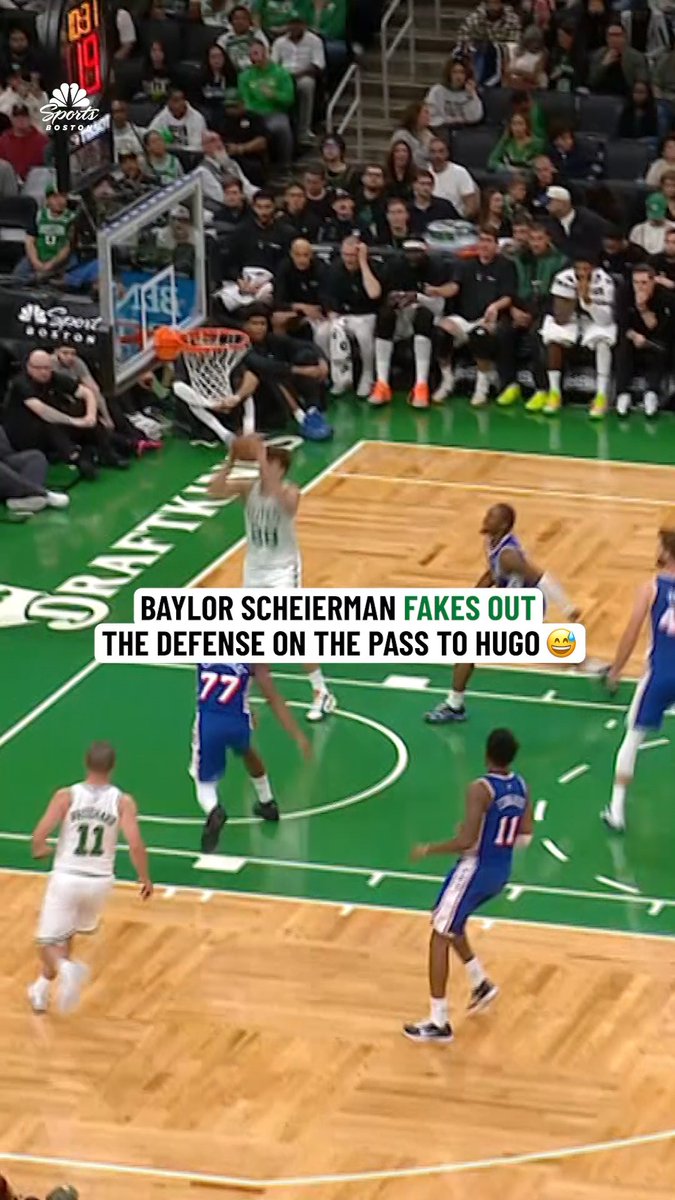 Baylor Scheierman fakes out the defense with a pump fake at the rim before passing to a teammate, as captured in this basketball clip with the caption "BAYLOR SCHEIERMAN FAKES OUT THE DEFENSE ON THE PASS TO HUGO 😁." The image reflects the post's reaction by showing how Scheierman ("got 'em") successfully fooled the defenders with his deceptive move.