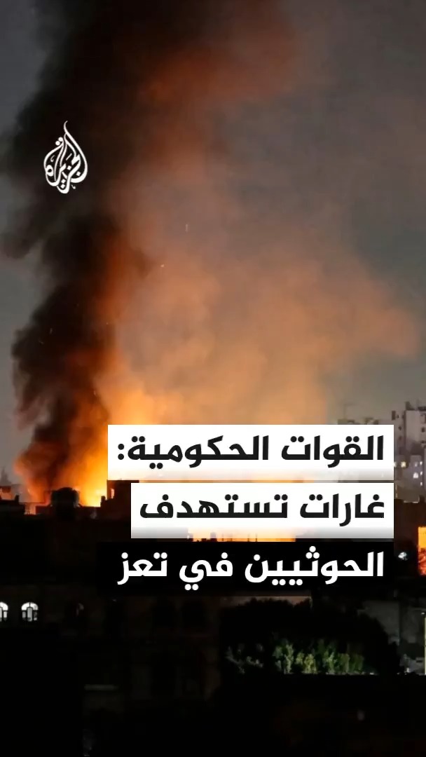 The image shows a large nighttime fire with thick smoke billowing into the sky over a cityscape, featuring Arabic text that reads "القوات الحكومية: غارات تستهدف الحوثيين في تعز" (Government forces: Airstrikes target Houthis in Taiz), along with the Al Jazeera logo. The caption relates to the post by visually depicting the aftermath of Yemeni government airstrikes on Houthi positions in Taiz.