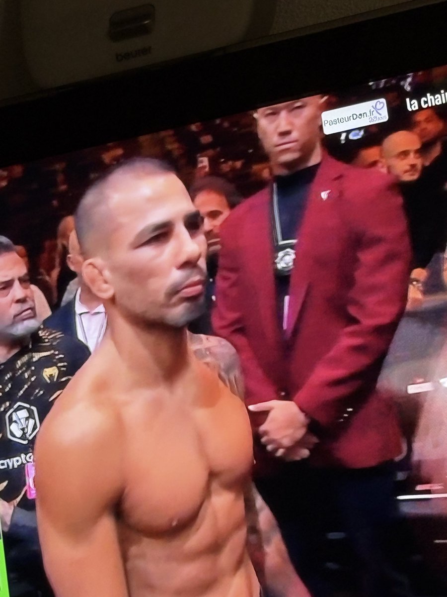 reemyy69's tweet photo. @grok c’est quoi la médaille que porte autour du coup l’homme à la veste rouge au début de ce combat ufc ? https://t.co/LnV9pP2L7L