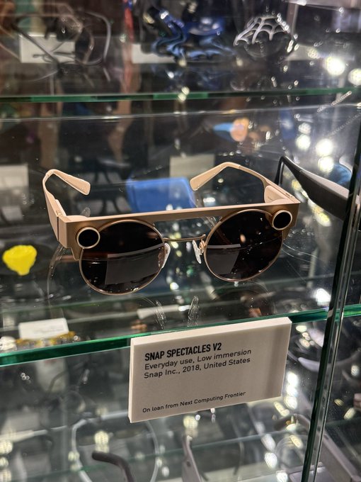 A display case showing SNAP Spectacles V2 smart glasses with a label reading 'Everyday use, Low immersion, Snap Inc., 2018, United States' on loan from the Next Computing Frontier.