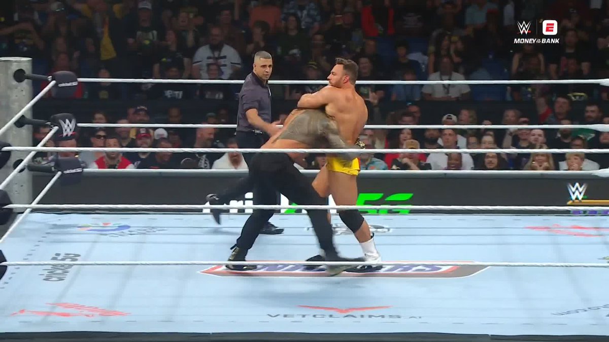 In a WWE ring during Money in the Bank, wrestler LA Knight (in yellow trunks) executes a move on an opponent while the referee watches closely, with the SNICKERS mat logo visible below.

This image captures the confident, in-ring action referenced in the post, showing LA Knight dominating his opponent mid-match at the Money in the Bank event.