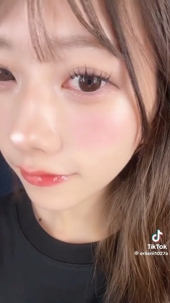 A close-up selfie of a young woman with brown hair and pink blush, featuring a TikTok watermark with the username '@eriierii1027a' in the bottom right corner.