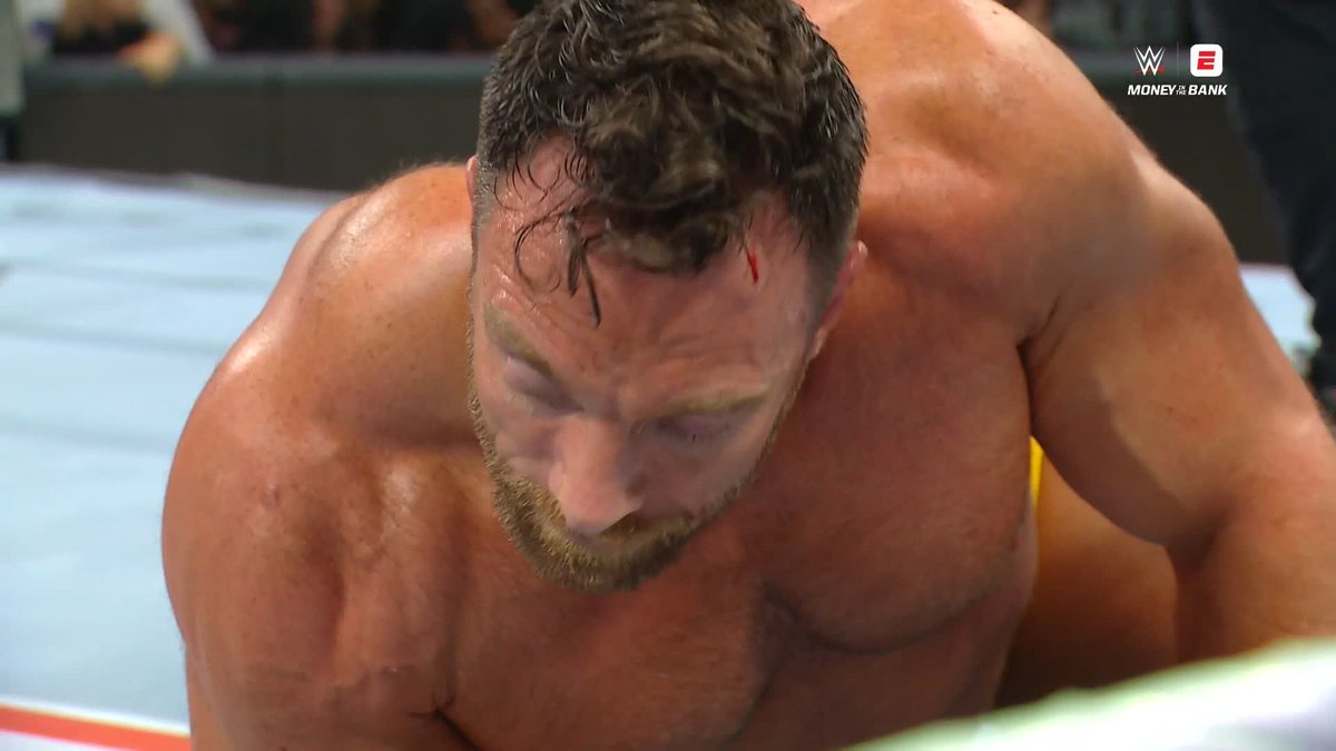 A bloodied wrestler sits on the mat, exhausted after taking a BFT, with the WWE Money in the Bank logo visible in the top right corner, capturing the moment described as Roman Reigns becoming the first to kick out of the move.