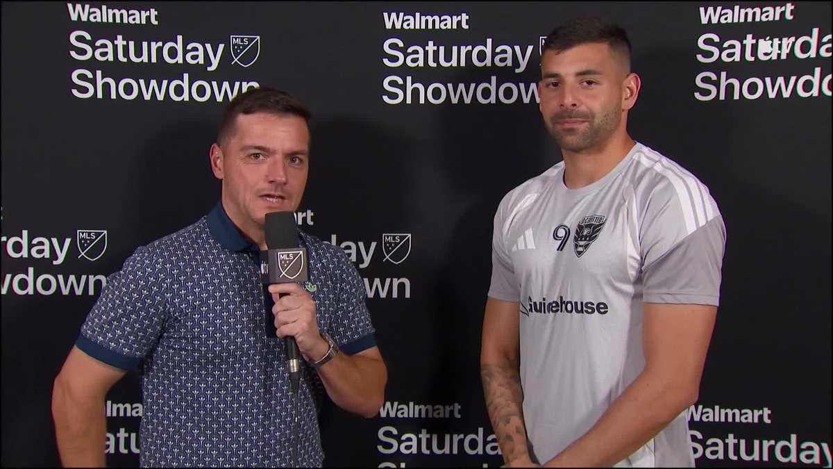 An MLS reporter holds a microphone while interviewing a soccer player wearing a number 9 jersey, standing in front of a 'Walmart Saturday Showdown' backdrop.