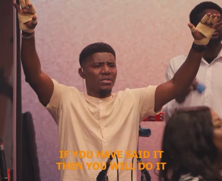 Worship scene showing a man with raised arms and bandaged hands, with text overlay reading 'IF YOU HAVE SAID IT THEN YOU WILL DO IT'.