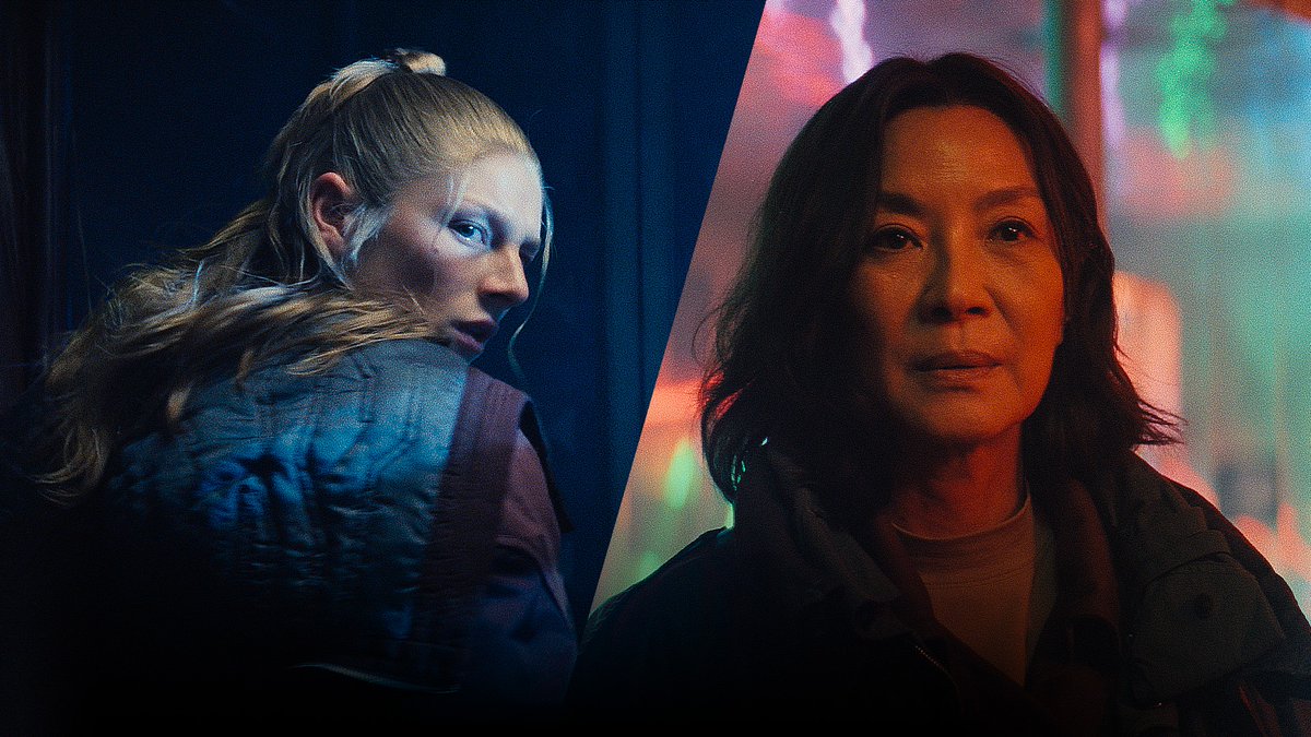 A split-screen cinematic image showing a blonde woman looking back over her shoulder on the left in blue lighting, and an Asian woman with dark hair in red lighting on the right.
