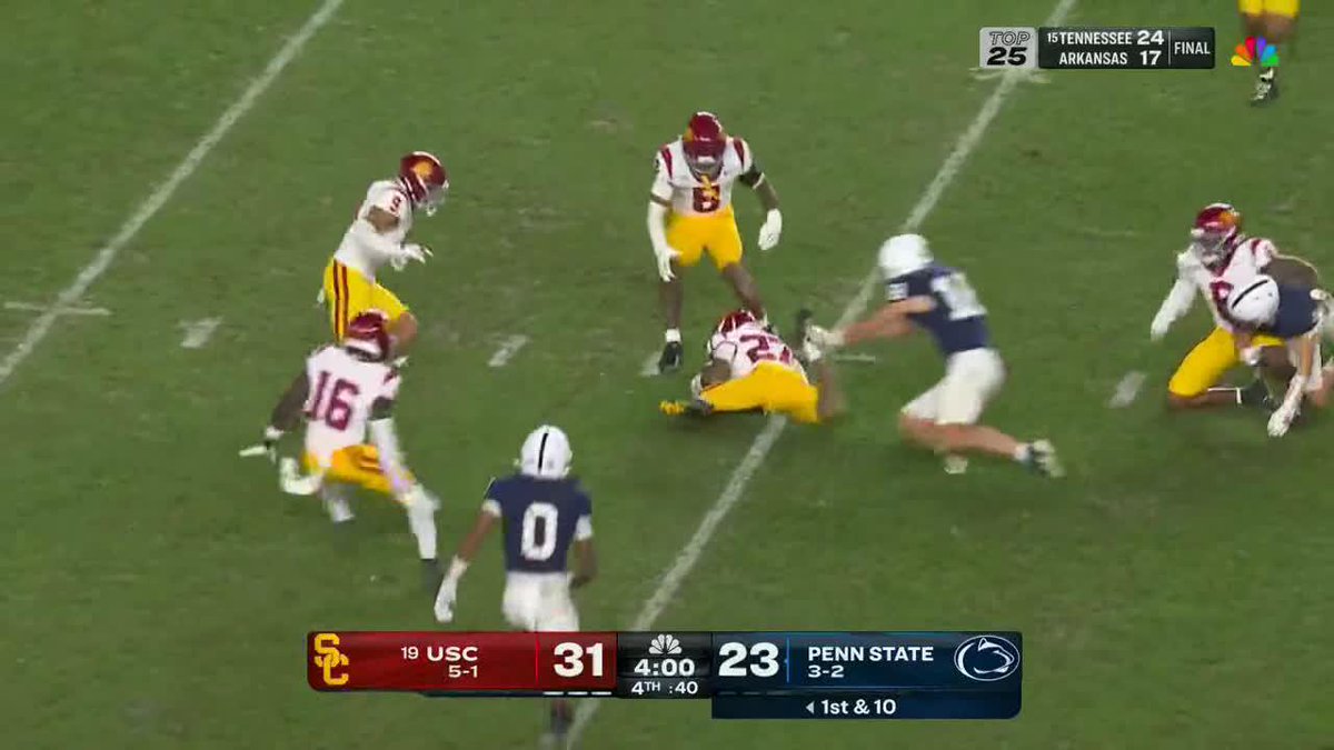 USC players in cardinal and gold celebrate recovering a fumble against Penn State on a 1st & 10 play with 4:00 remaining in the 4th quarter, leading 31-23, as shown on the NBC broadcast scoreboard.