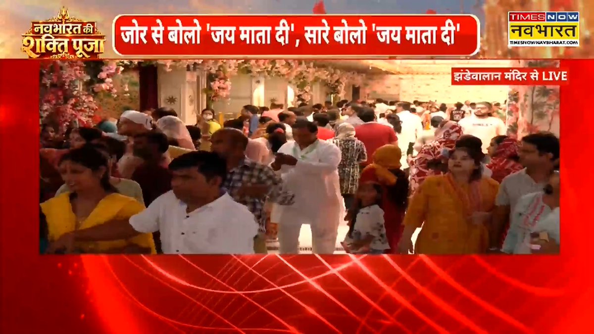A Times Now Navbharat news broadcast displays a Hindi headline reading 'जोर से बोलो 'जय माता दी', सारे बोले 'जय माता दी'' alongside 'नवभारत की शक्ति पूजा' branding, showing a live feed from a decorated temple filled with a large crowd of devotees.