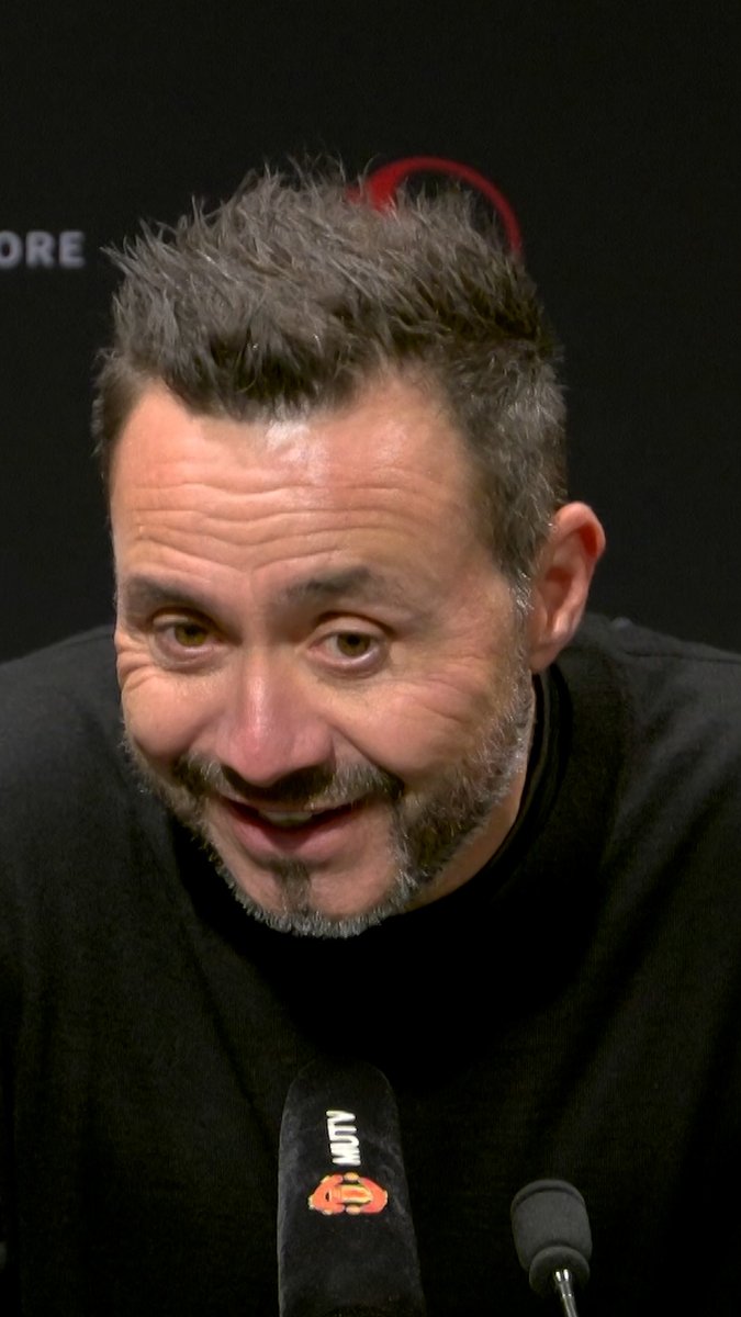 A man with short spiky hair and a beard speaks into a microphone with "MUTV" displayed on it, as he is being interviewed. Given the context of the post discussing Tottenham Spurs' manager Roberto De Zerbi and the MUTV branding (Manchester United TV), the image likely relates to a post-match interview following a Premier League match at Old Trafford.