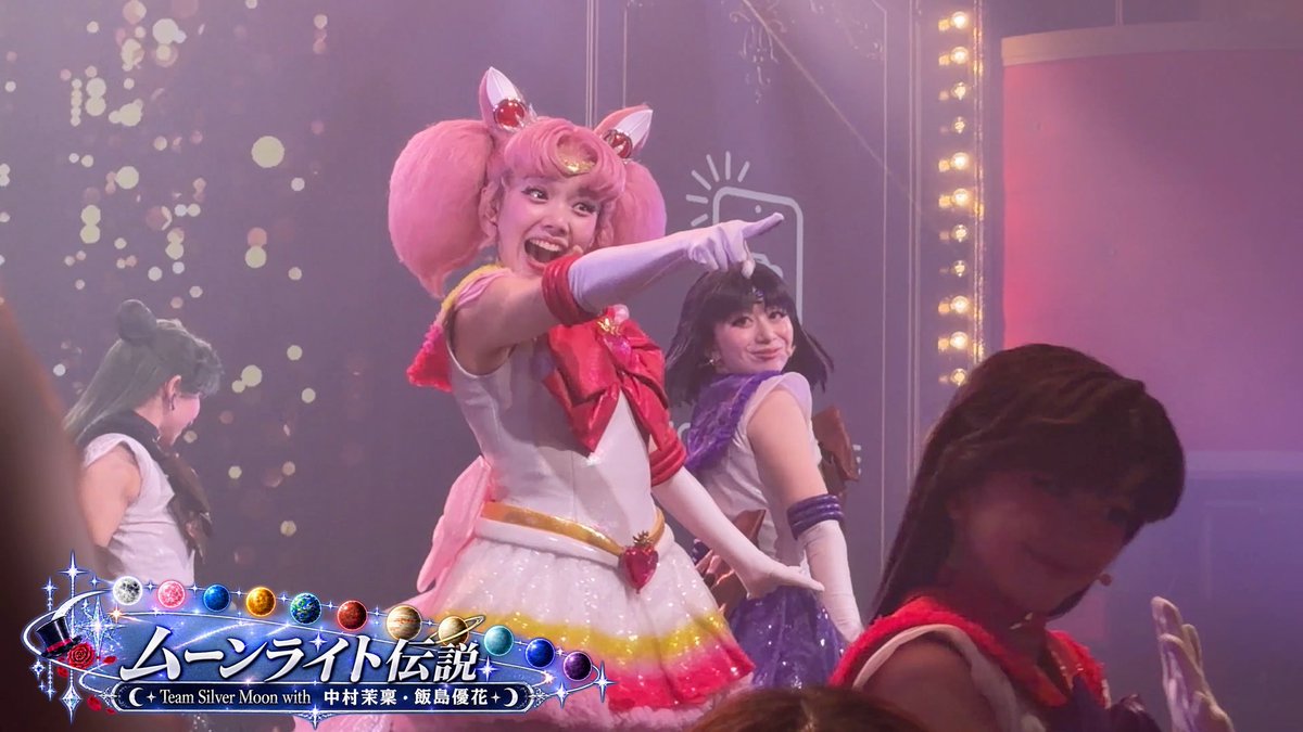 Performers in Sailor Moon costumes on stage during a 'ムーンライト伝説 (Moonlight Densetsu)' show featuring 'Team Silver Moon with 中村茉菜・飯島優花'.
