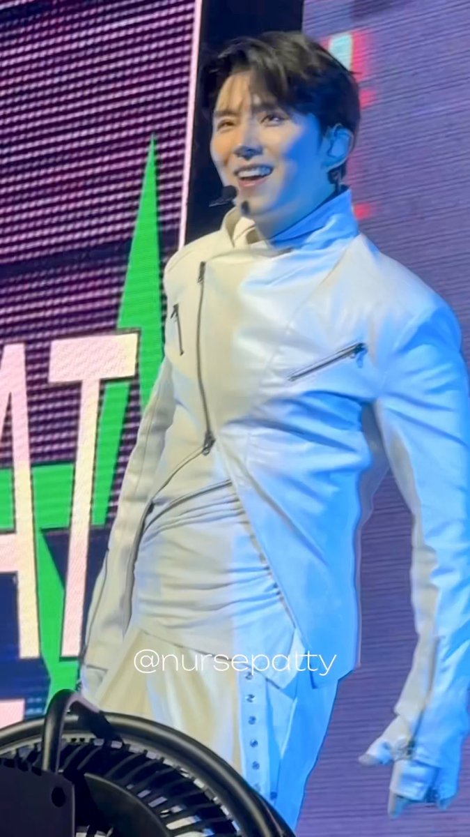 A performer in a white leather jacket and pants smiles while standing on stage, with a watermark reading '@nursepatty'.