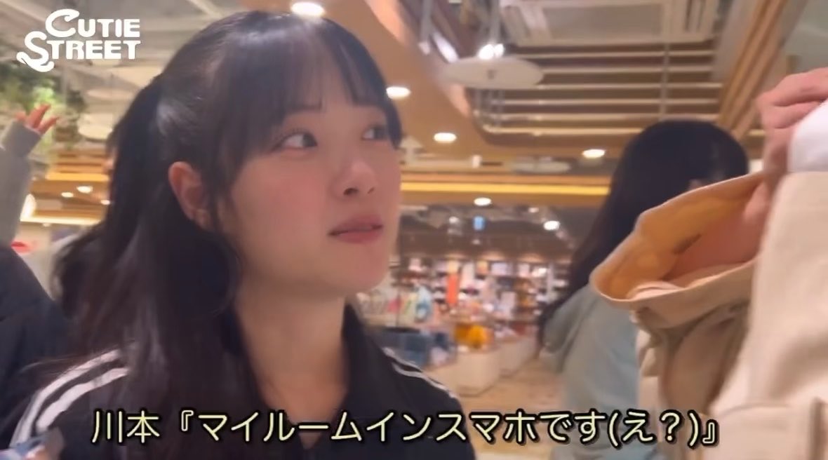 A young woman with dark hair looks off-camera in a mall setting; Japanese subtitles read "川本『マイルームインスタです(え？)』" with "CUTIE STREET" in the top left corner.