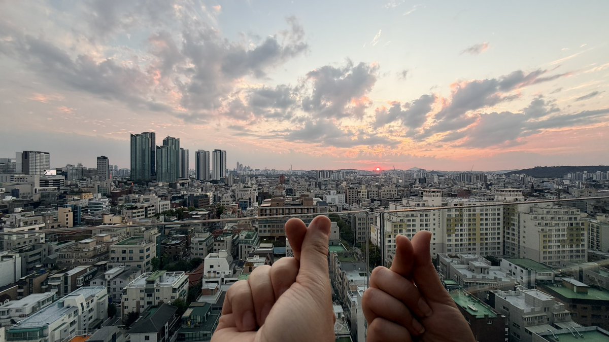 CapsLockKeyon's tweet photo. We found out our hotel has a rooftop! First sunset in Seoul. https://t.co/8KsBnDQ97i