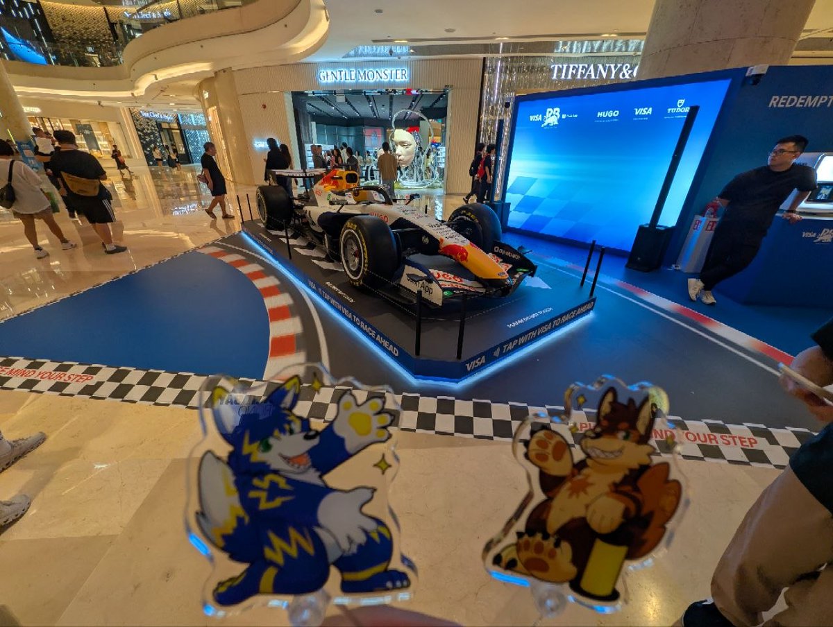 Lurozeroc's tweet photo. 昨天帶上阿爾傑特和盧洛，出發去感受新加坡 F1 大獎賽的狂熱氣氛！🏎️✨

我們先去商場裡拍了超帥的賽車展示，像是 Visa Cash App RB 和 Mercedes-AMG Petronas 賽車。現場擠滿了瘋狂拍照的車迷，近看真的太過癮了！📸 接著一路散步到 3A Stamford 入口閘門那邊去湊熱鬧，雖然沒進場，但光是看到滿滿興奮的觀眾和周邊的封街，就能感受到心跳加速的賽事氛圍！🔥
最後，我們晃到了超美麗的讚美廣場 (CHIJMES)！在這座歷史建築前，看著戶外大螢幕上的 Live 轉播，和大家一起為賽車手們歡呼加油，為這趟追車之旅畫下完美的句點 🏁🍻

🐺 阿爾傑特： 整個城市都被 F1 淹沒了！光是在外圍散步湊熱鬧就夠好玩了！ 🎈
盧洛： Squeak! 在讚美廣場看大螢幕轉播超熱鬧！雖然本充氣狼這次沒有幫忙打到氣，但我有在旁邊當最稱職的加油吉祥物喔！💪🎈

Yesterday, I took Arzeht & Luro (in their compact standee forms!) out to catch some F1 Singapore Grand Prix fever! 🏎️✨

We started by checking out the incredible F1 car displays in the malls (like Visa Cash App RB & Mercedes-AMG Petronas). The crowds were wild, but we managed to capture their sleek speed beast look! 📸 Then we headed over to Gate 3A Stamford just to soak in the lively F1 night race atmosphere
seeing the eager crowds and hearing the buzz of the track from the outside was so hype! 🔥
To wrap up our day, we wandered over to CHIJMES to watch the live race broadcast on the big outdoor screen. Gathering there with everyone against the historic backdrop was the perfect finish to our adventure! 🏁🍻

🐺 Arzeht: The F1 energy is absolutely everywhere! Even without entering the track, soaking up the atmosphere and seeing the show cars was thrilling!🎈 Luro: Squeak! Watching the race at CHIJMES was super exciting[cite: 24]! While this inflatable wolf still couldn't pump anything, I was the best cheer mascot for everyone watching the big screen! 💪🎈

#SingaporeGP #F1 #Furry #InflatableFurry #AcrylicStandee