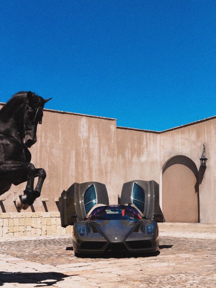 Indie5051's tweet photo. Estas fotografías fueron tomadas  en Hacienda Pastejé, en Jocotitlán, Estado de México, donde un Ferrari Enzo junto  con un caballo negro, crearon  una escena en la que el icónico emblema de la marca pareció cobrar vida. https://t.co/JxWZywuciL