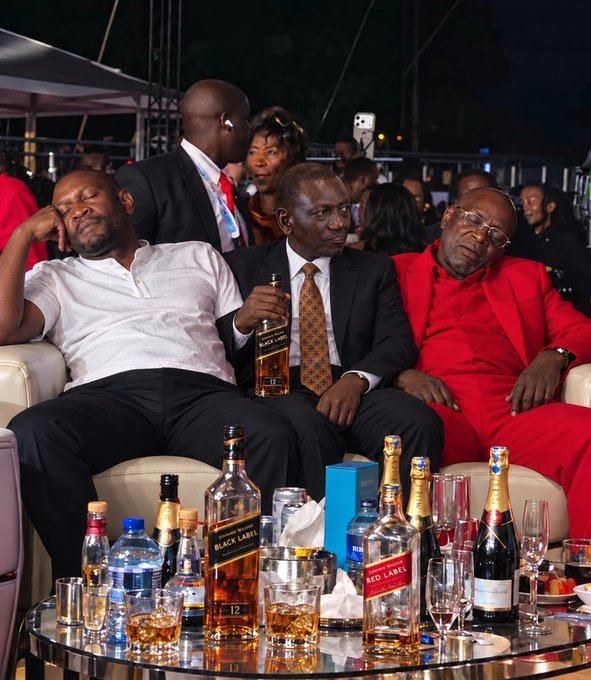 TONY_KMW's tweet photo. @grok @NaekuMercy Found one photo (attached blw).

Pls confirm if photo is real or ai, and then id person in the middle holding a bottle of something (allegedly). https://t.co/Z2ze9B40g6