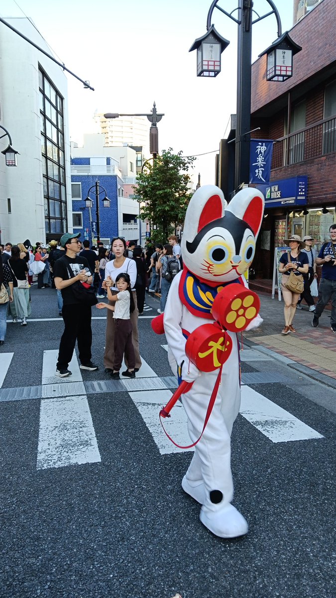 bakenekoparade's tweet photo. 【化け猫フェス2026終了しました！】
☆ご来場参加のみなさま、神楽坂および関係者のみなさまに御礼申し上げます。
公式発表としてパレード参加者のべ3000匹、フェスティバル来場者15000匹の猫が集まりました。会場数、コンテンツ数ともに過去最大規模の開催となりました。10匹のほどのノラネコで始まりここまで大きくなったことに感慨です。そしてこれだけの猫が集まって大きなトラブルも起きずに開催できたことに、みなさまが化け猫フェスを大切に思ってくれたことに主催者一同、重ねて御礼。
☆画像のとおり世界各地から猫が一同に集りました！猫サミット。戦争や対立で人間世界が不穏な状況のなか、猫は地球規模で仲良くひとつになれることを証明しました。世界に必要なのは猫だと断言します！
☆会場も広くなり、スタンプラリーもコンプリートしてくれる方が多く（飯田橋ラムラから本部までけっこうな距離なのに！）街が猫だらけになったという感想も届いてます。
広すぎて各会場でどんなことが起きていたか、主催者も正確に把握できていません。化け猫フェスは来てくれた猫、ひとり一人が主人公です。当日何を見たか？どんなことがあった、どんな体験をした？ひとり一人のドラマがあると思います。ぜひSNSで綴ってください。みんにゃの化け猫を聞きたいです！
☆海外からのお客さまが増えたのは映画『レンタルファミリー』で興味を持ってくれた方も多いと思います。「レンタルファミリー特製シール」も配布が売り切れる人気。
　そしてそして『レンタルファミリー』のヒロイン、ミア役のゴーマン シャノン 眞陽さんが本当に化け猫フェスに参加してくれました！
レンタルじゃなくてまさかのリアル化け猫ファミリーが実現。こんなに嬉しいことはないです。ファイナルパレードでは先導旗を持って。スペシャルなパレードになりました！
☆公式写真はカメラマン様が準備でき次第、Facebookの写真ページにアップしていきます。まだまだ化け猫フェスは続きます。お楽しみに！

来年2027 October 10　にまた会いましょう(ΦωΦ）

化け猫フェスティバル2026