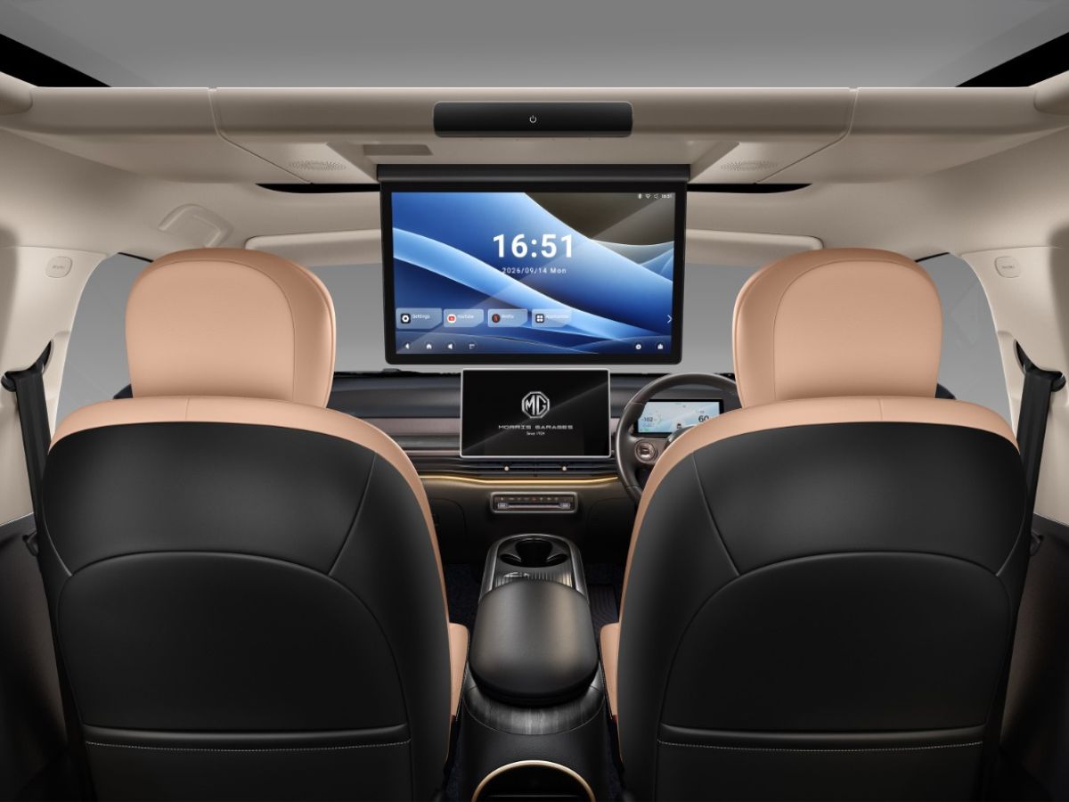 MotorOctane's tweet photo. MG Windsor EV Gets A BMW-Style Rear Entertainment Screen!

-> Windsor Indulge Edition launched @ Rs. 17.89 lakh (ex-showroom)
-> Roof-mounted entertainment screen for rear passengers (flip-down) 
-> New Shadow Gold exterior colour 
-> Black-painted 18-inch alloy wheels
-> Black-and-tan leather upholstery
-> 'Indulge Edition' badging 
-> Indulge-branded cushions and neck pillows 
-> Available only with the smaller 38 kWh battery pack | 332 km range | 136 bhp | 200 Nm