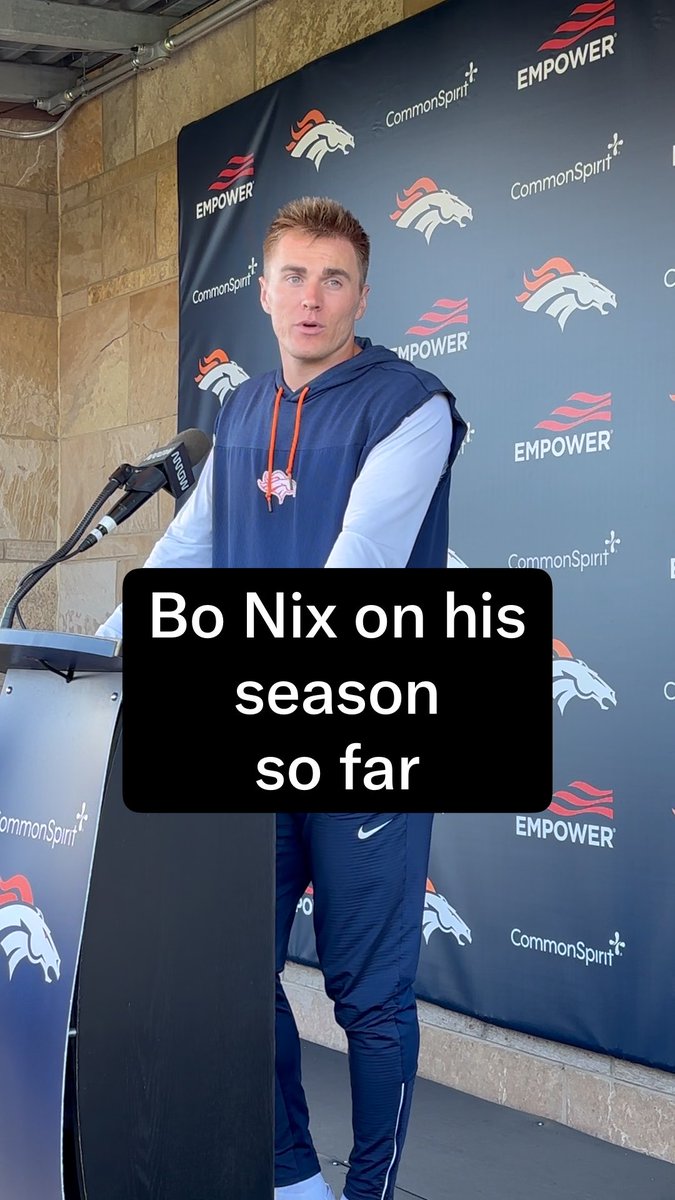 Denver Broncos quarterback Bo Nix addresses reporters at a press conference, standing at a podium with microphones against a backdrop displaying Empower and CommonSpirit sponsor logos alongside the Broncos logo. The image, captioned "Bo Nix on his season so far," accompanies a post discussing his struggles and a recent quote where he downplayed the narrative around his inconsistent performance, suggesting the Broncos may be in trouble.