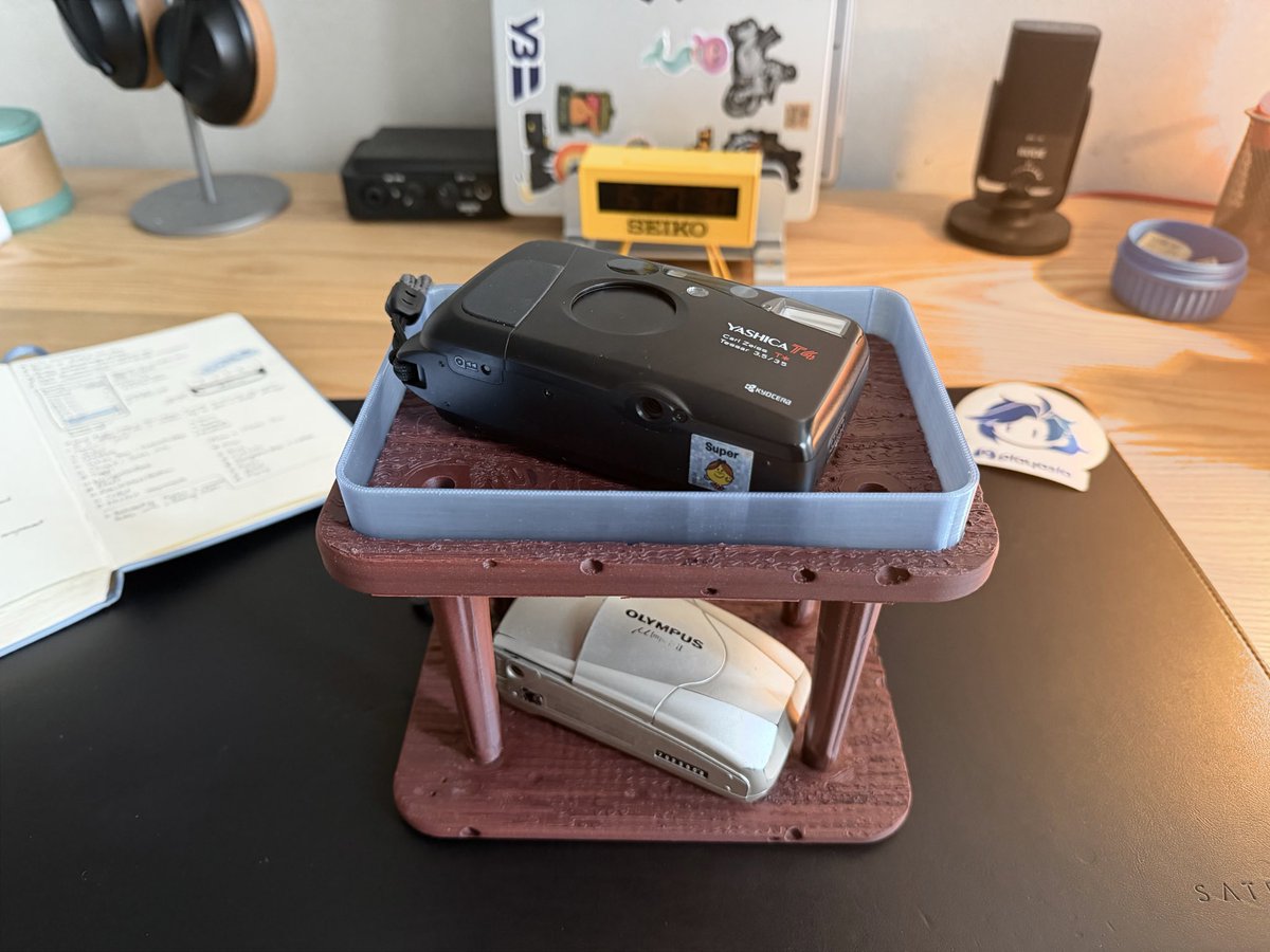 anwsme's tweet photo. Hey @claudeai, make me a 3D model of the stand for my film cameras. Shelves should have a wooden texture printed in PLA, the stand should be extendable, and there should be a glass rim around using translucent PETG. https://t.co/ewgmlzBxjH