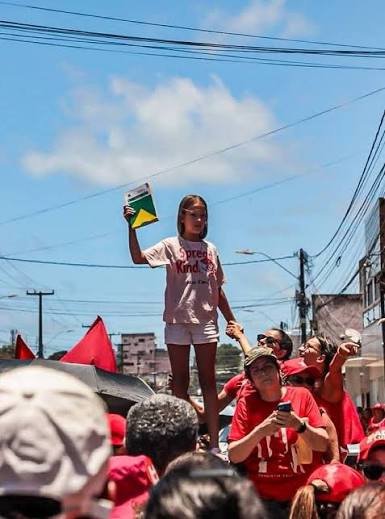 BiazitaGomes's tweet photo. A propaganda eleitoral de Flávio Bolsonaro disse que todos os manifestantes que estão na rua lutando pela democracia são bandidos.
Para o Flávio essa menina segurando a constituição é uma bandida por lutar pelos seus direitos.
Lutar pela democracia é errado para ele.
Certo é ser amigo do Vorcaro né