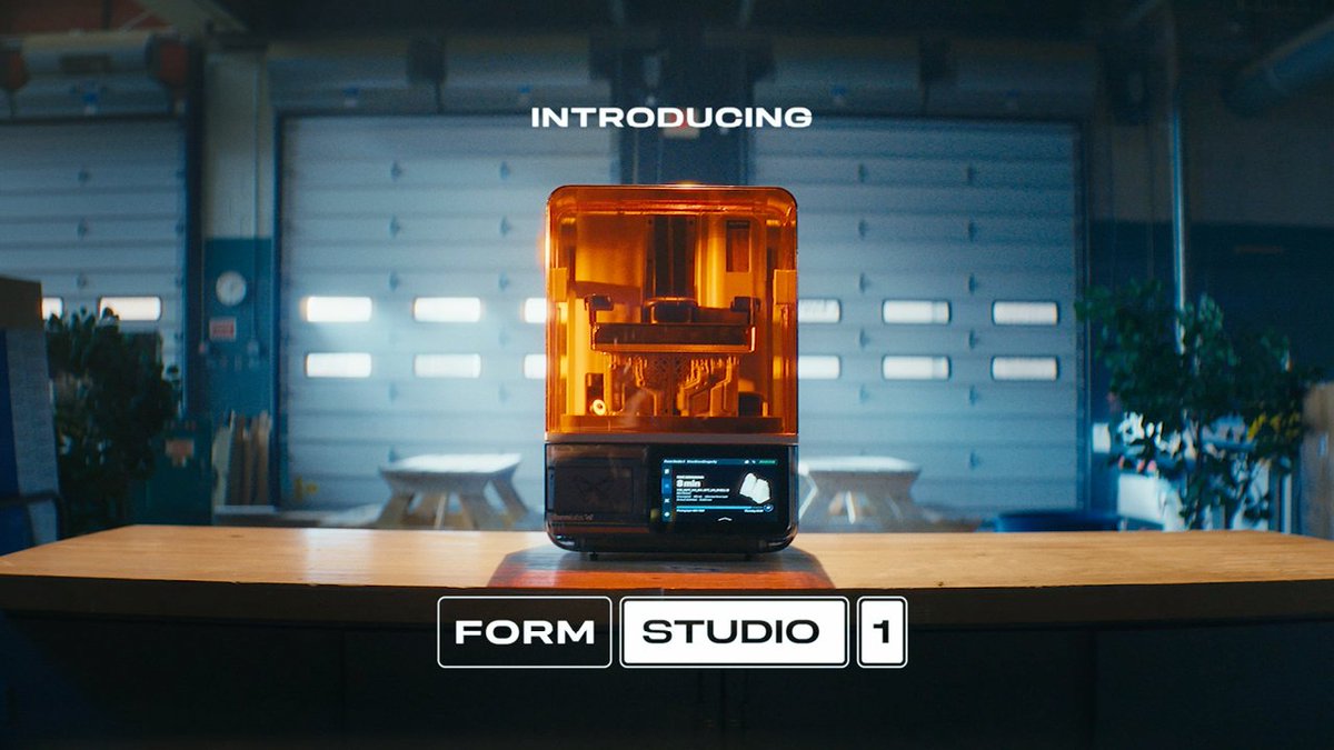 A promotional image introducing 'FORM STUDIO 1,' showing an orange-tinted 3D printer-like device with a digital display screen, placed on a wooden table in what looks like a garage or workshop setting.