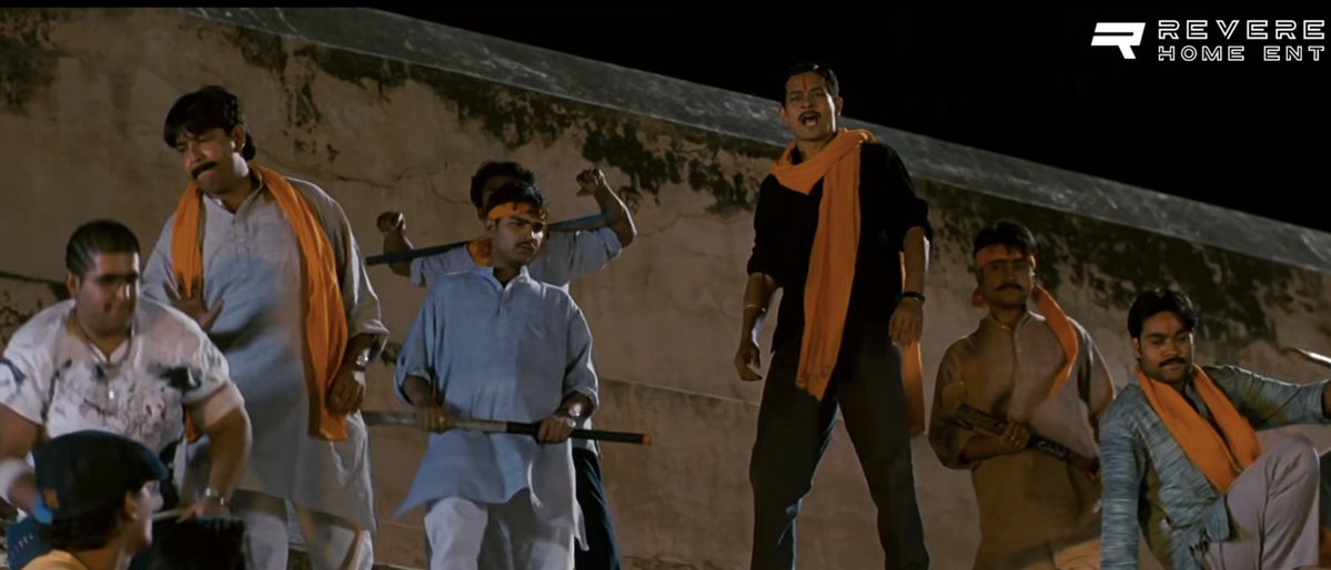 indusreunited's tweet photo. Propaganda in Rang De Basanti. 
It was actually the CONGRESS that was heavily involved in Mig 21 scams. 

Movies use various colours deliberately to drive association and emotion. The antagonist is draped in colours what is generally associated with the Indian Right Wing(ie not the Congress).  
> The colour of the gamchas, clothing  
> the colour of objects in the room(like a bag) 
> Interestingly, when one of the antagonist joins the documentary(even before the Mig 21 accident), they remove his orange tilak.   

When it was actually the Congress that was heavily involved in Mig 21, why portray these colours?