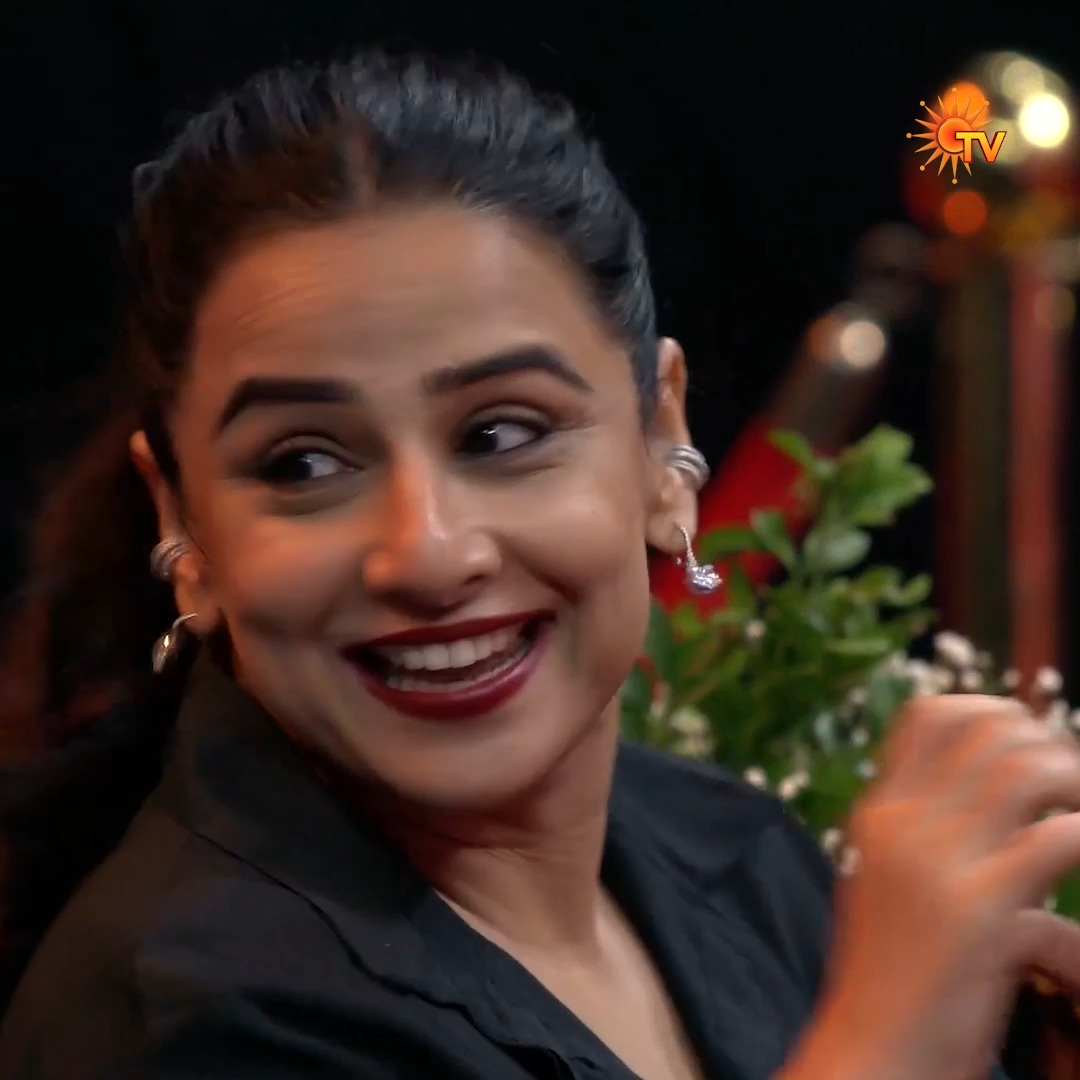 The image shows a woman with dark hair pulled back, wearing a black top and earrings, smiling warmly with what appears to be red lipstick, with a "GTV" logo visible in the upper right corner. The caption relates to the post as Vidya Balan, mentioned alongside Ramya Krishnan by Superstar Rajinikanth in connection with the Jailer 2 Super Show on Sun TV.
