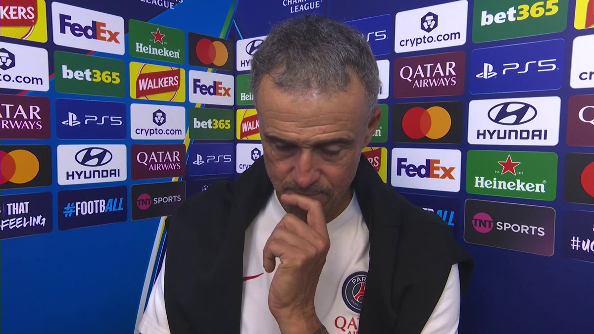 A man wearing a Paris Saint-Germain top appears in a post-match interview against a backdrop featuring UEFA Champions League sponsors like FedEx, Heineken, bet365, and Qatar Airways.