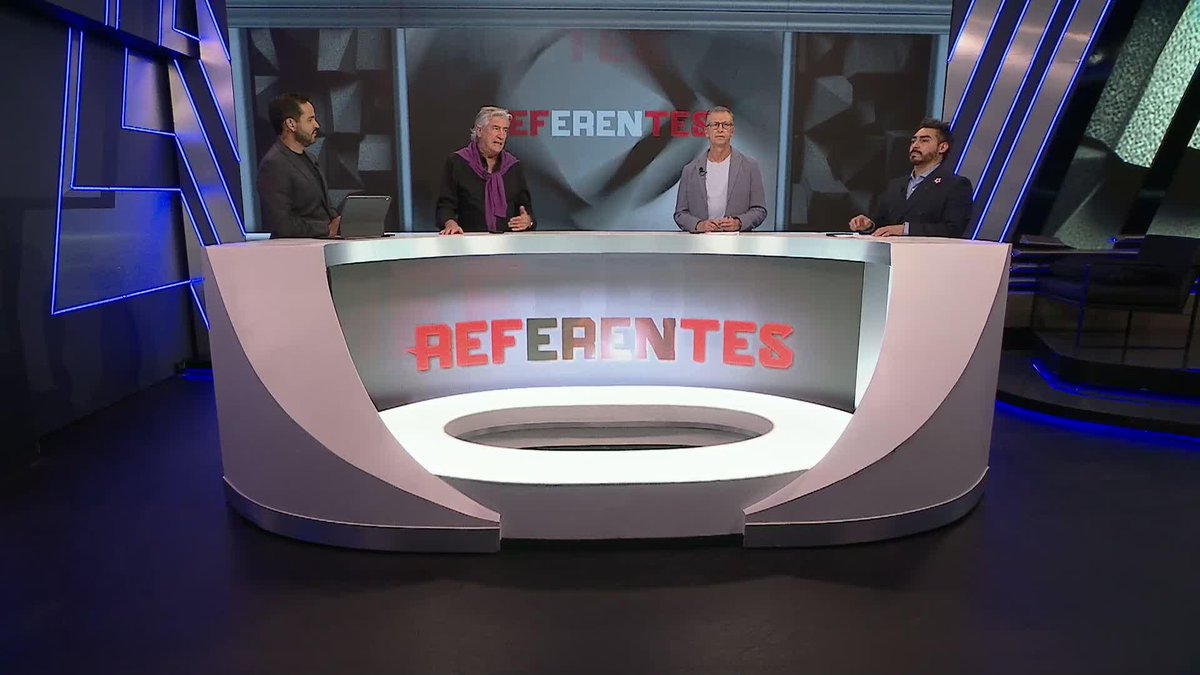 Four men stand behind a modern studio desk displaying the word "REFERENTES" in red letters.