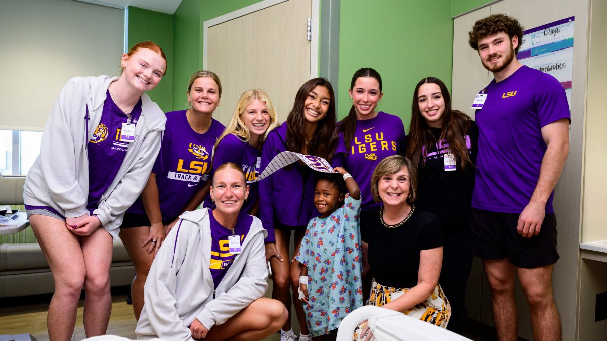 LSUpresident's tweet photo. Miss Angela joined @LSUGym @LSUTrackField and @LSUBeachVB to bring a little purple and gold to the children at @FMOLHealth Children’s Hospital. We are grateful to our student-athletes for sharing their time and hearts with these young Tigers and their families. @Athletesforhope @ololchildrens #LSU