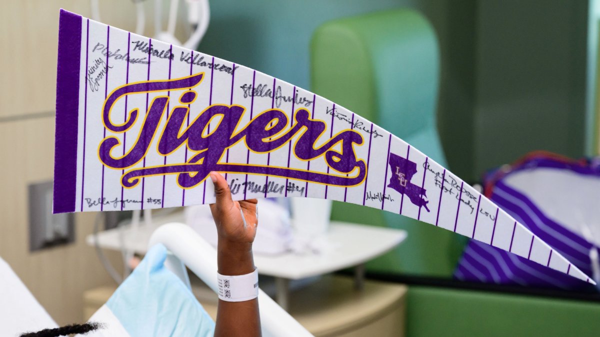 LSUpresident's tweet photo. Miss Angela joined @LSUGym @LSUTrackField and @LSUBeachVB to bring a little purple and gold to the children at @FMOLHealth Children’s Hospital. We are grateful to our student-athletes for sharing their time and hearts with these young Tigers and their families. @Athletesforhope @ololchildrens #LSU