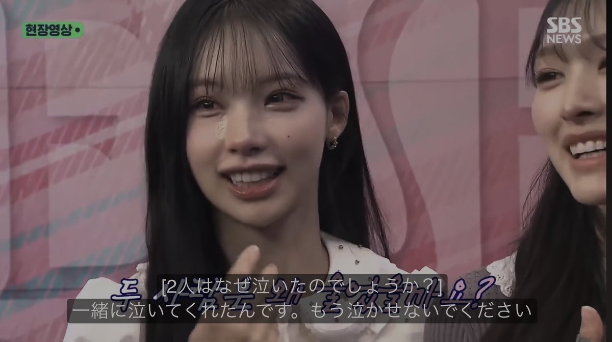 A screenshot from SBS NEWS featuring a young woman smiling with a tear on her cheek, with Japanese subtitles and Korean text '현장영상'.